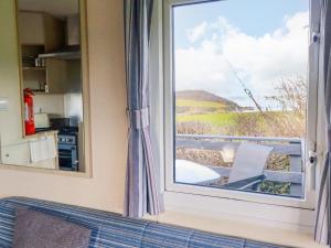 a window with a view of the countryside from a kitchen at Little Trevorrick Caravan in Wadebridge +13 photos