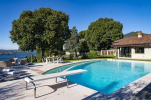 a swimming pool with a table and chairs next to a house at Villa Anna Lake View in Pilzone
