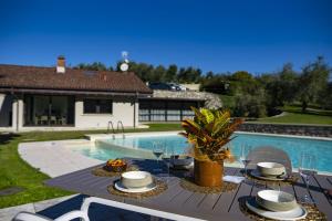 a table with plates of food next to a swimming pool at Villa Anna Lake View in Pilzone