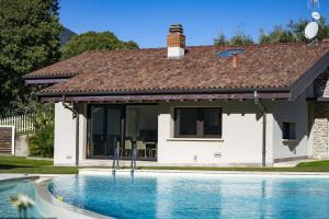 a house with a swimming pool in front of it at Villa Anna Lake View in Pilzone