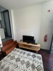 Una sala de estar con una mesa de café y un televisor. en Villa R Relíquia, en Machico