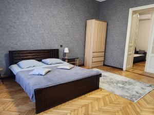 a bedroom with a large bed with two pillows on it at O.O.APART.2 in Chernivtsi