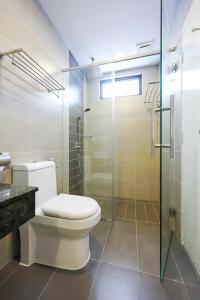 a bathroom with a toilet and a glass shower at Grand Ion Genting Highlands in Genting Highlands