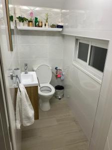 a small bathroom with a toilet and a sink at Master hosting Gal in Bet Sheʼan +15 photos