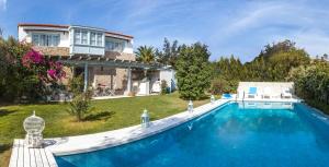 a large swimming pool in front of a house at Alura Hotel in Alacati