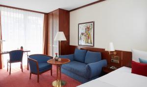 una stanza d'albergo con un divano blu e un tavolo di Living Hotel Weißensee a Berlino