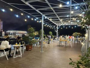 a rooftop patio with people sitting at tables at night at SOCA Hotel LAO CAI in Lao Cai