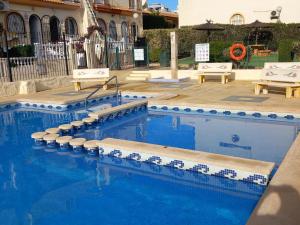 a swimming pool with blue and white tiles on it at La Florida Apartment Near Emerald Isle Complex in Orihuela Costa