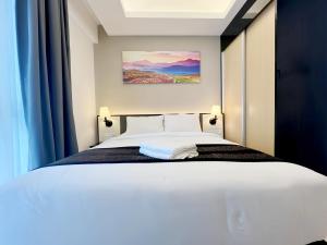 a bedroom with a white bed with blue curtains at Grand Ion Genting Highlands in Genting Highlands