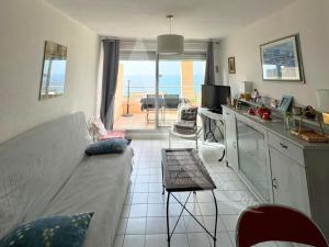 Il comprend un salon avec un canapé et une cuisine avec vue. dans l'établissement appartement 1 chambre vue dominante mer, à Sète