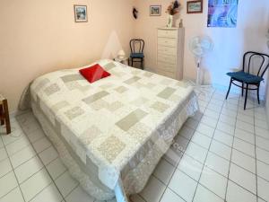une chambre avec un lit avec un oreiller rouge dessus dans l'établissement appartement 1 chambre vue dominante mer, à Sète 23 autres photos