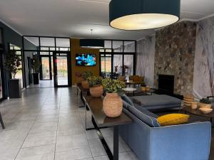 Una sala de estar con un sofá azul y un televisor. en Xiluva Flower Smart Apartment, en Midrand