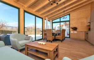 a living room with a table and chairs and windows at Beautiful Villa Lara with sauna in Imotski in Kamenmost