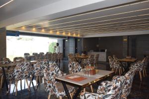 a dining room with tables and chairs in a room at Country Ambience Hotel in Haldwāni