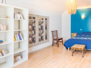 sypialnia z łóżkiem, krzesłem i półkami na książki w obiekcie Charmante maison 1930 centre Hennebont, déco actuelle, terrasse, jardin clos, 2 chambres, wifi inclus - FR-1-349-204 w mieście Hennebont