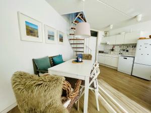 ein Wohnzimmer mit einem weißen Tisch und einem Stuhl in der Unterkunft Liguster 74* in Nieuwvliet + 11 Fotos