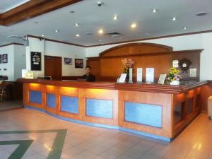 Ein Mann steht an einer Bar in einer Lobby. in der Unterkunft Sanbay Hotel in Sandakan