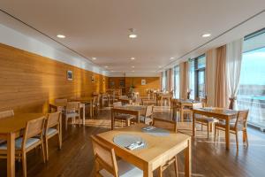 a restaurant with wooden tables and chairs and windows at Hotel da Graciosa in Santa Cruz da Graciosa