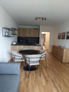 a living room with a table and chairs and a kitchen at Ferienwohnung Stephanie im Landhotel Seeg in Seeg