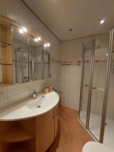 a bathroom with a sink and a shower at Ferienwohnung Stephanie im Landhotel Seeg in Seeg