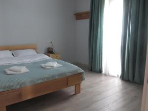a bedroom with a bed with two towels on it at Guesthouse Bacha Lia in Mestia