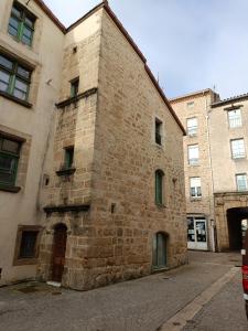 an old brick building on a city street at La maison du prieur in Langogne