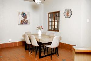 Un comedor con mesa y sillas en Ukhanya resort, en Midrand