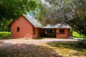 un edificio rojo con un garaje y un árbol en Ukhanya resort, en Midrand