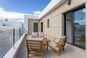 a balcony with a wooden table and two chairs at Villa Nica in Dolores