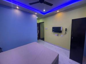 a room with a bed and a ceiling fan at Park kasba Inn in Kolkata +10 photos