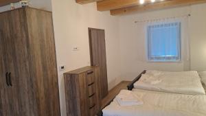 ein Schlafzimmer mit zwei Betten und einem Holzschrank in der Unterkunft Apartmán Nové Město na Moravě - Maršovice in Nové Město na Moravě + 11 Fotos