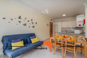 un soggiorno con un divano blu e un tavolo di #273 Pedra dos Bicos M by Home Holidays ad Albufeira Altre 43 foto