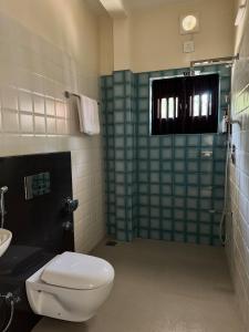 a bathroom with a toilet and a sink and a shower at The Kumberi Manor in Ammatti +7 photos