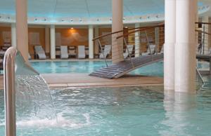 a swimming pool with a staircase in a building at Hotel Caesius Thermae & Spa Resort in Bardolino