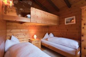 une cabane en rondins avec 2 lits dans une chambre dans l'établissement Ferienhaus Gasteg, à Maria Alm