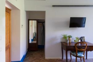 a room with a table and a television on a wall at Agriturismo Morani in Santa Severa