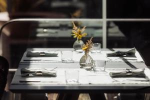 a table with glasses and a vase with flowers on it at Domìa Boutique Hotel e Cucina in Mondello