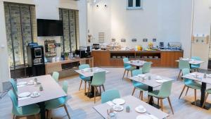 a dining room with tables and chairs and a kitchen at Hotel Sardinero Madrid in Madrid