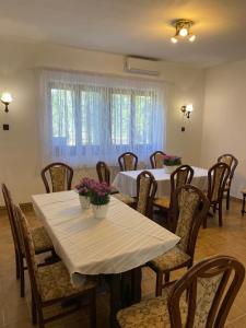 a dining room with tables and chairs with flowers on them at Gold Apartman in Zamárdi