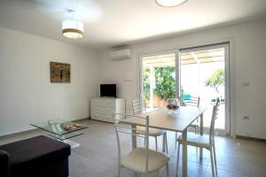 a living room with a table and chairs and a dining room at Villa Fertilia - Key to Villas in Fertilia