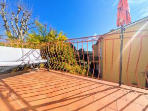 a balcony with a fence and a bench on it at Le Nid Ensoleillé in Les Arcs sur Argens +2 photos