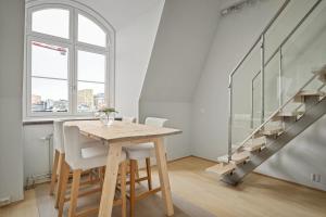 a dining room with a table and a staircase at Urban Oslo Penthouse with Fireplace & City Views in Oslo