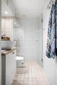 Un baño blanco con lavabo e inodoro. en Urban Oslo Penthouse, en Oslo