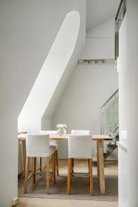 Un comedor con una mesa y sillas blancas. en Urban Oslo Penthouse, en Oslo