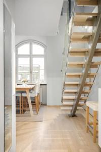 a kitchen and dining room with a staircase and a table at Urban Oslo Penthouse with Fireplace & City Views in Oslo +22 photos