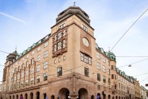 a large brick building with a clock on it at Urban Oslo Penthouse with Fireplace & City Views in Oslo