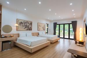 a large bedroom with two beds and a television at Thiên Trường An Garden in Ninh Binh