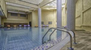 a large swimming pool with chairs in a building at Hotel Ville Des Roses in Dilida