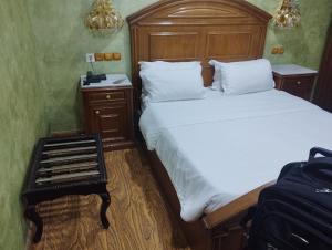a bedroom with a large bed and a suitcase at Hotel Ville Des Roses in Dilida +20 photos