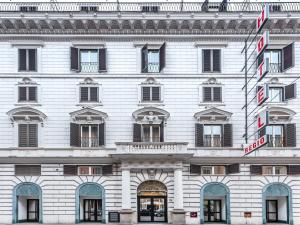 a large white building with a sign on it at Raeli Hotel Regio in Rome